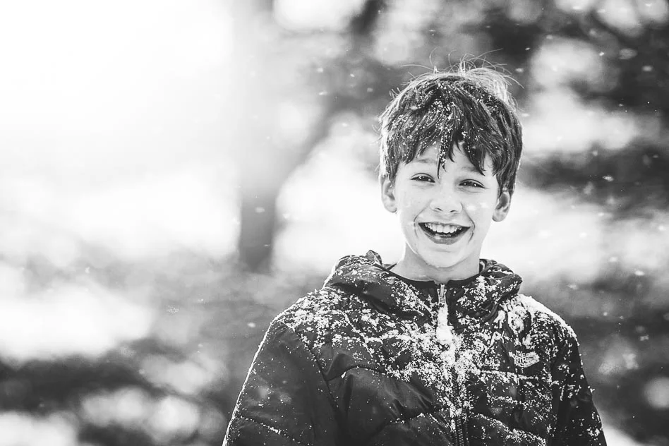 Black and white image of boy playing in snow