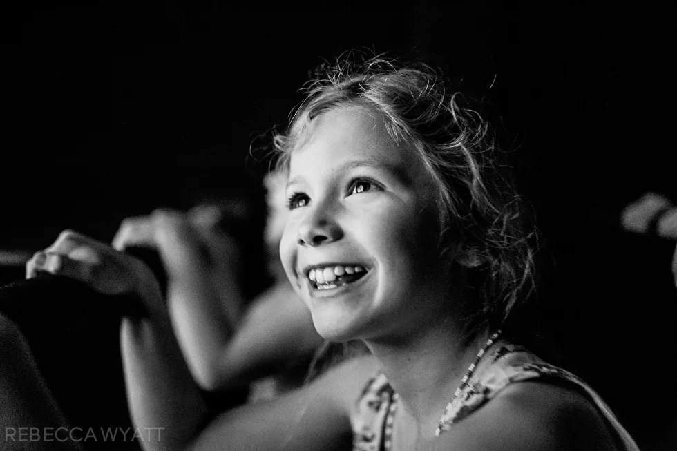 Captivating black and white photograph of girl smiling on an amusement ride.