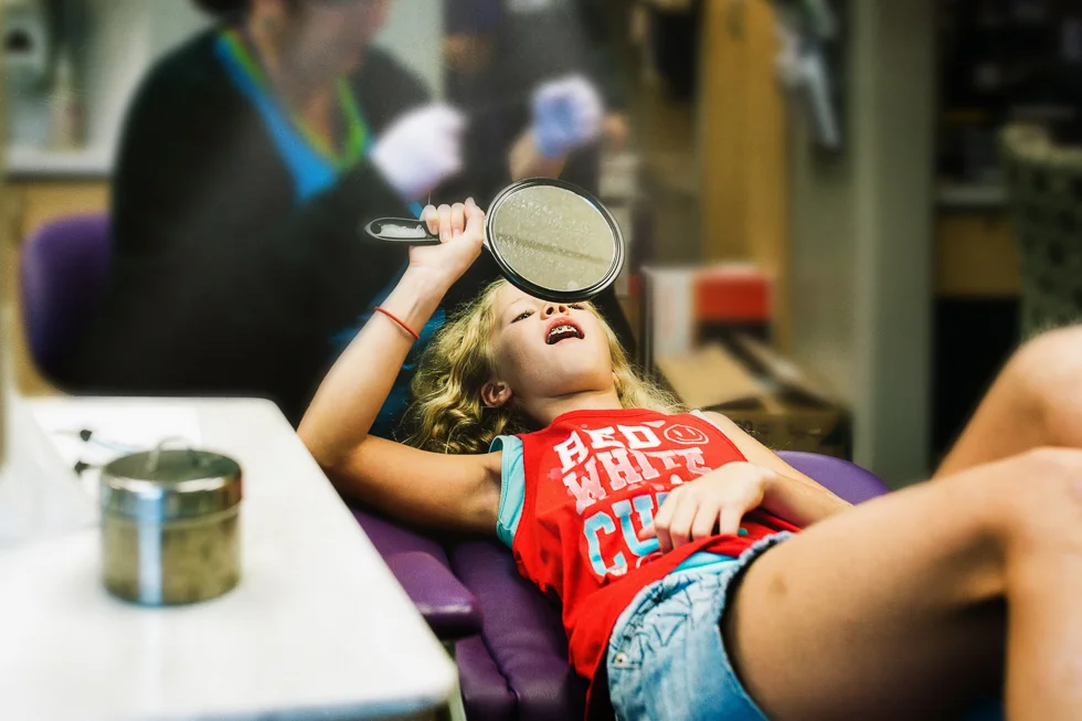 girl in orthodontists office getting braces