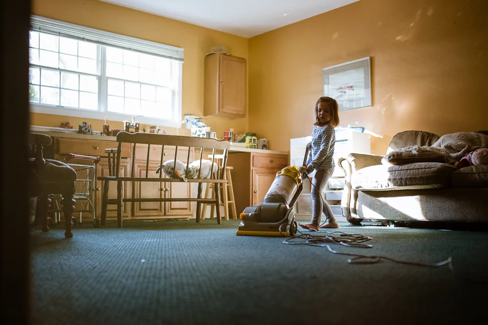color photo of little girl vacuuming playroom