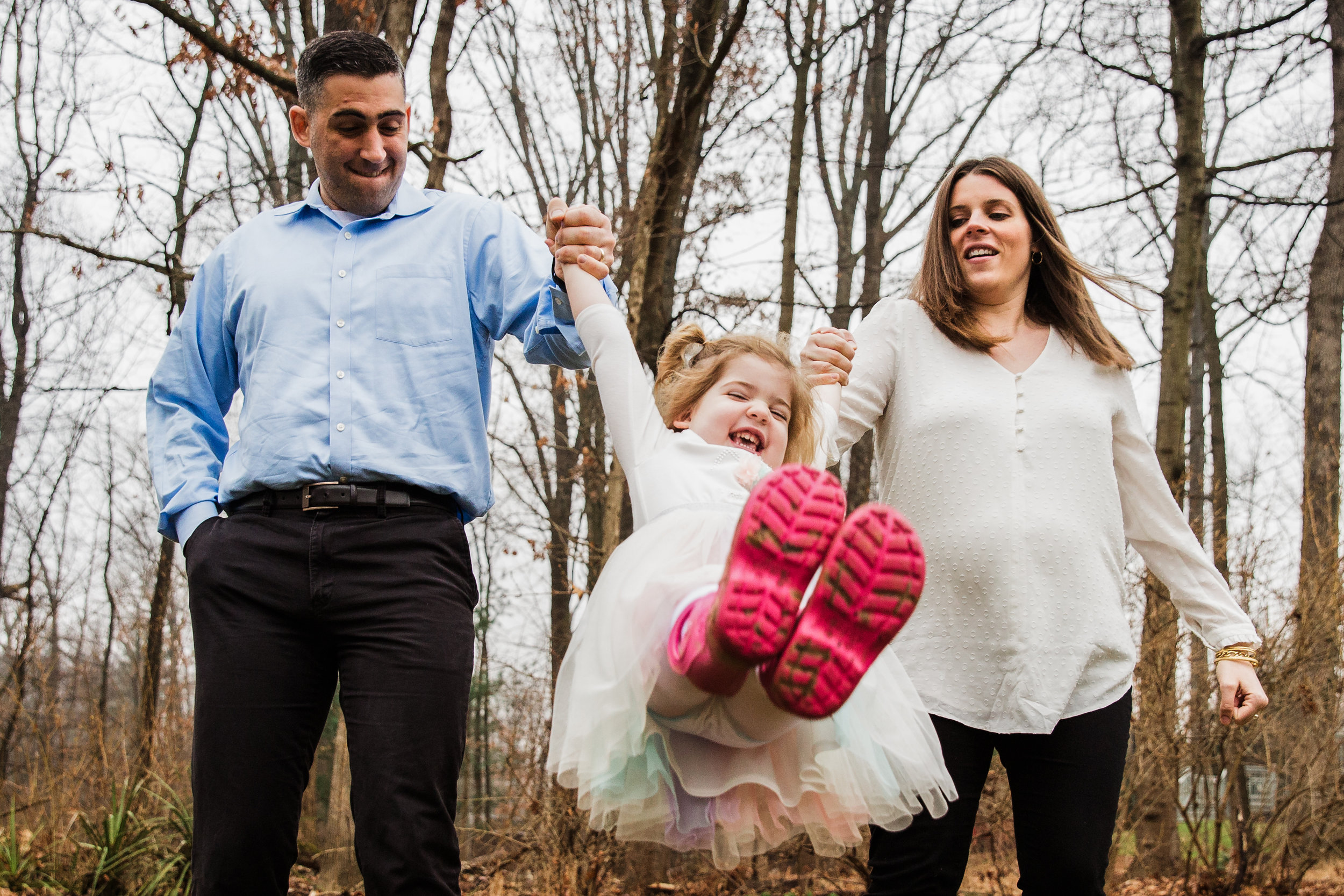 parents swing their daughter between them as they walk and she raise