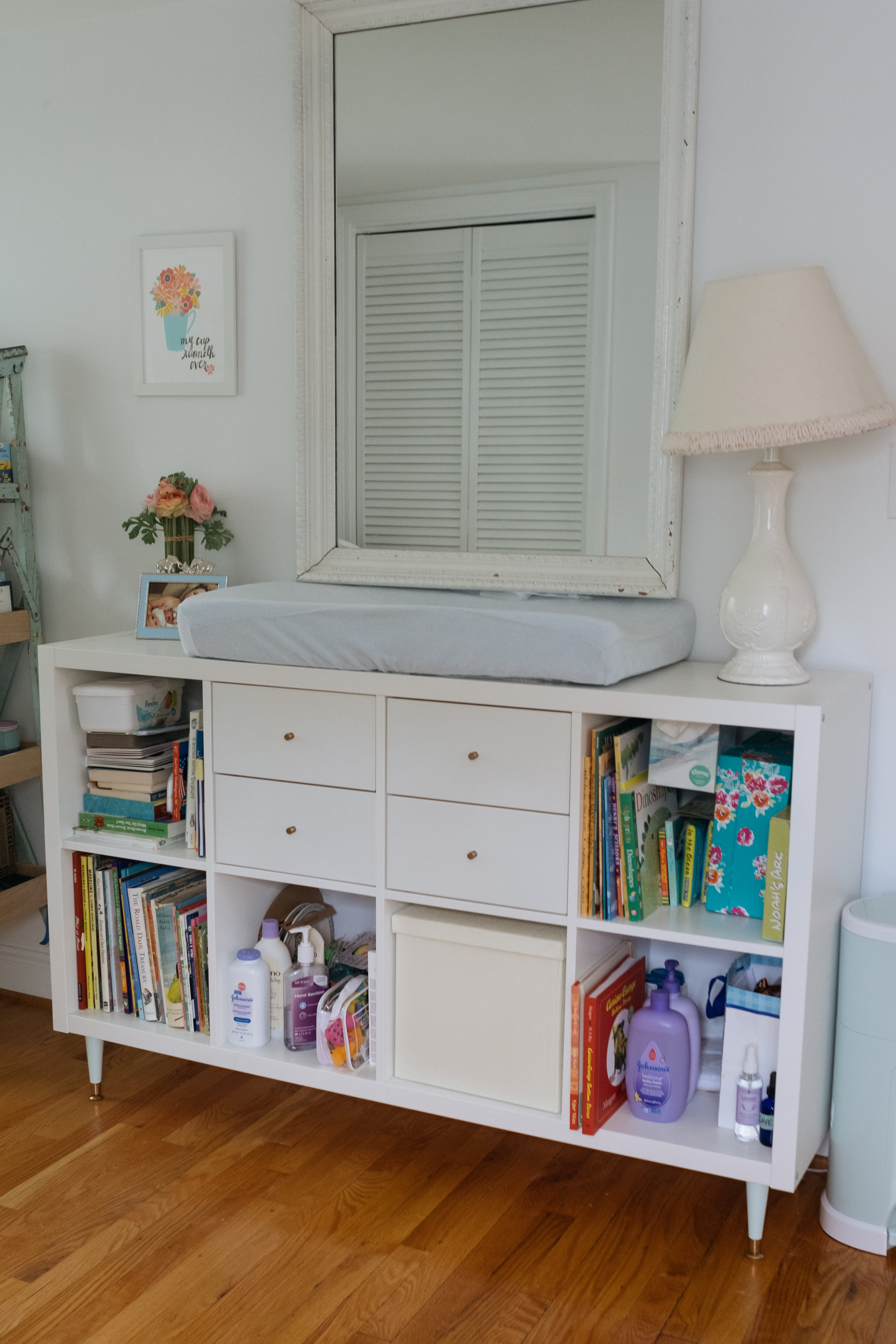 space in baby boy bedroom with dresser and changing table and antique mirror