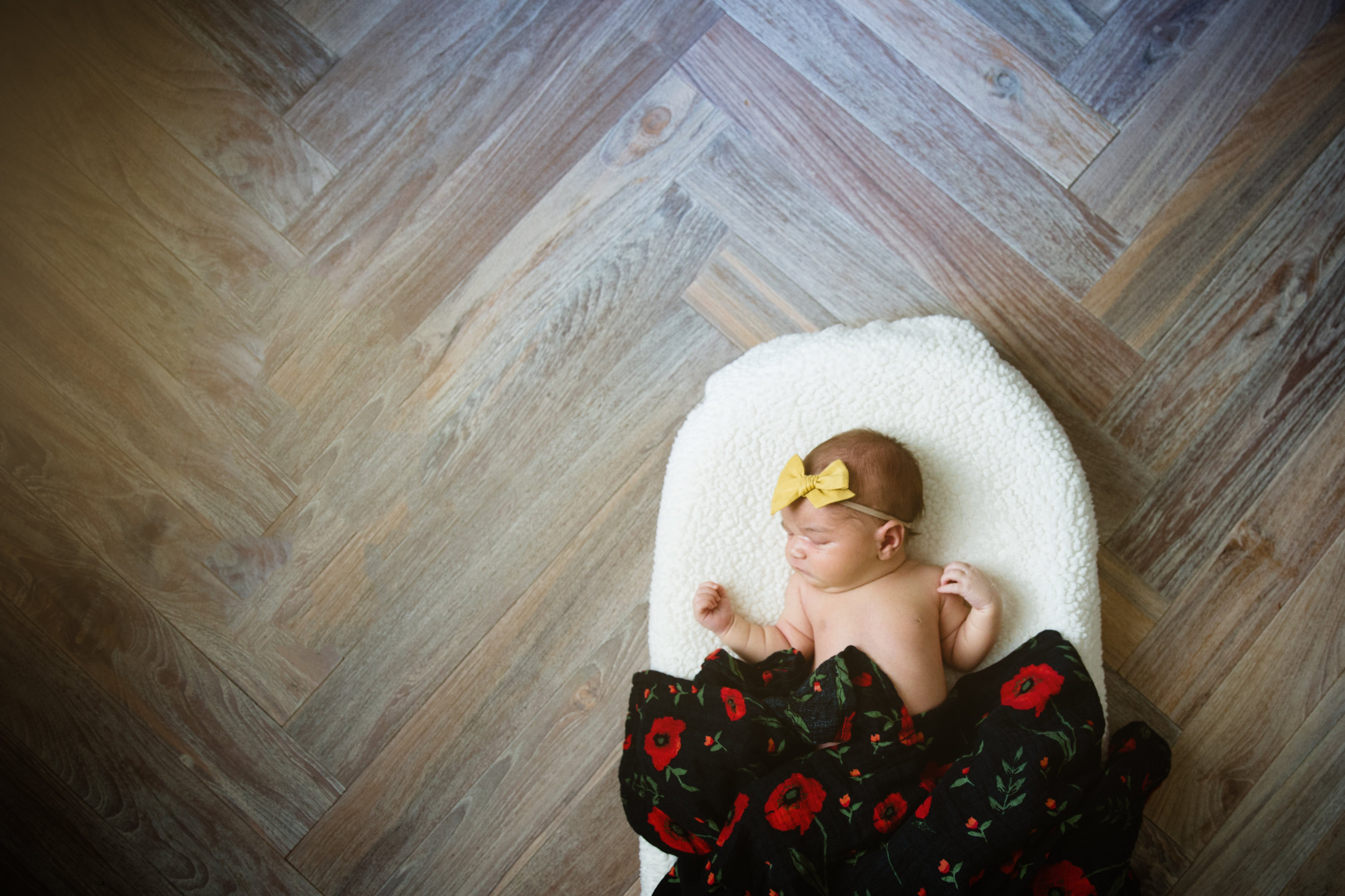 newborn baby sleeps on blankets with gorgeous hardwood floors
