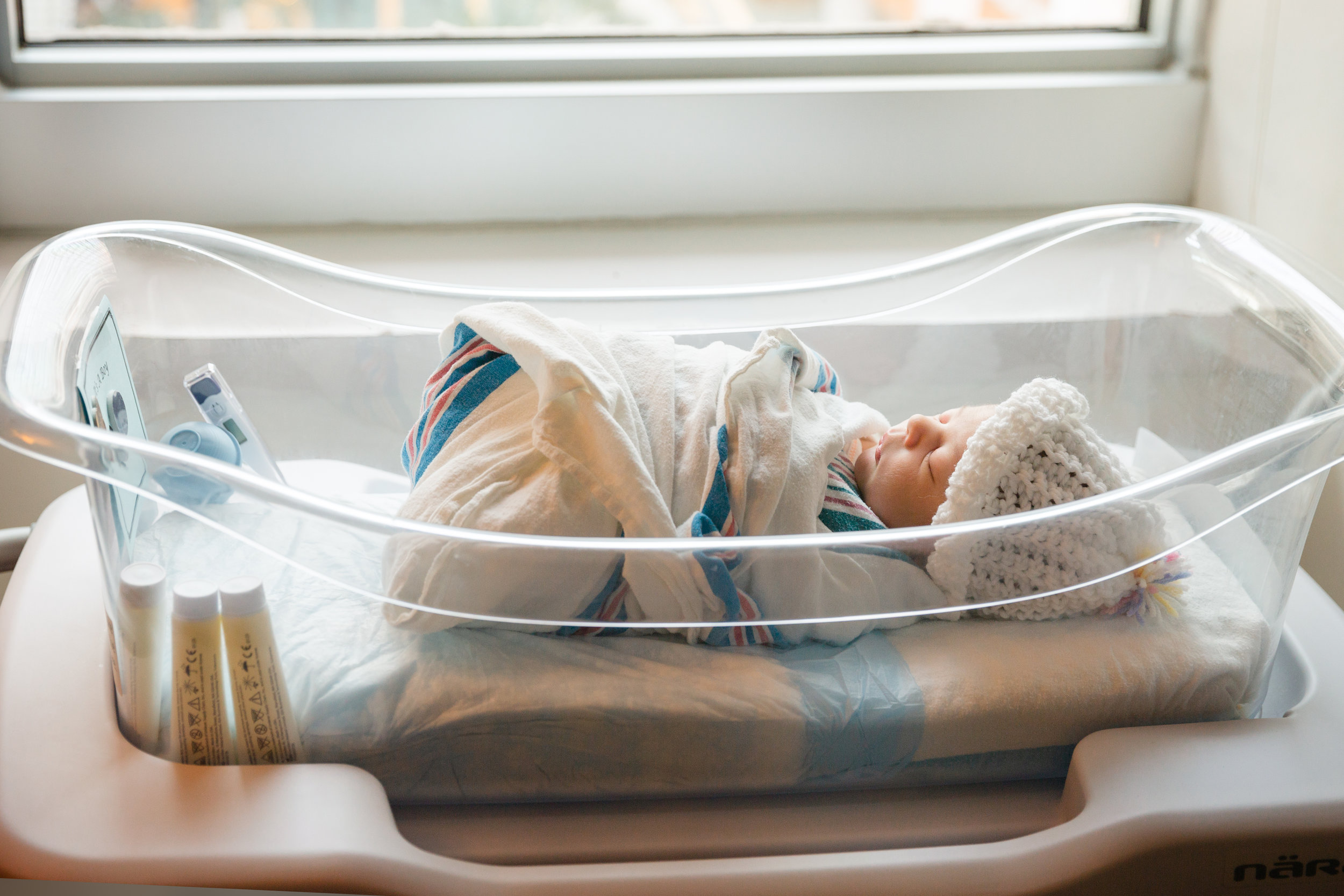 newborn baby boy photographed in hospital basset by window