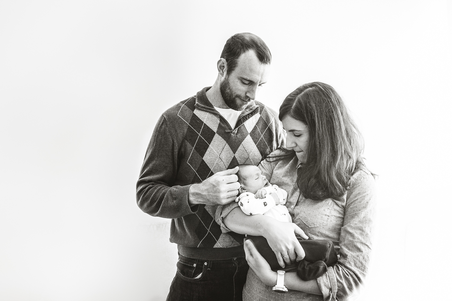 new parents hold newborn daughter in black and white photograph