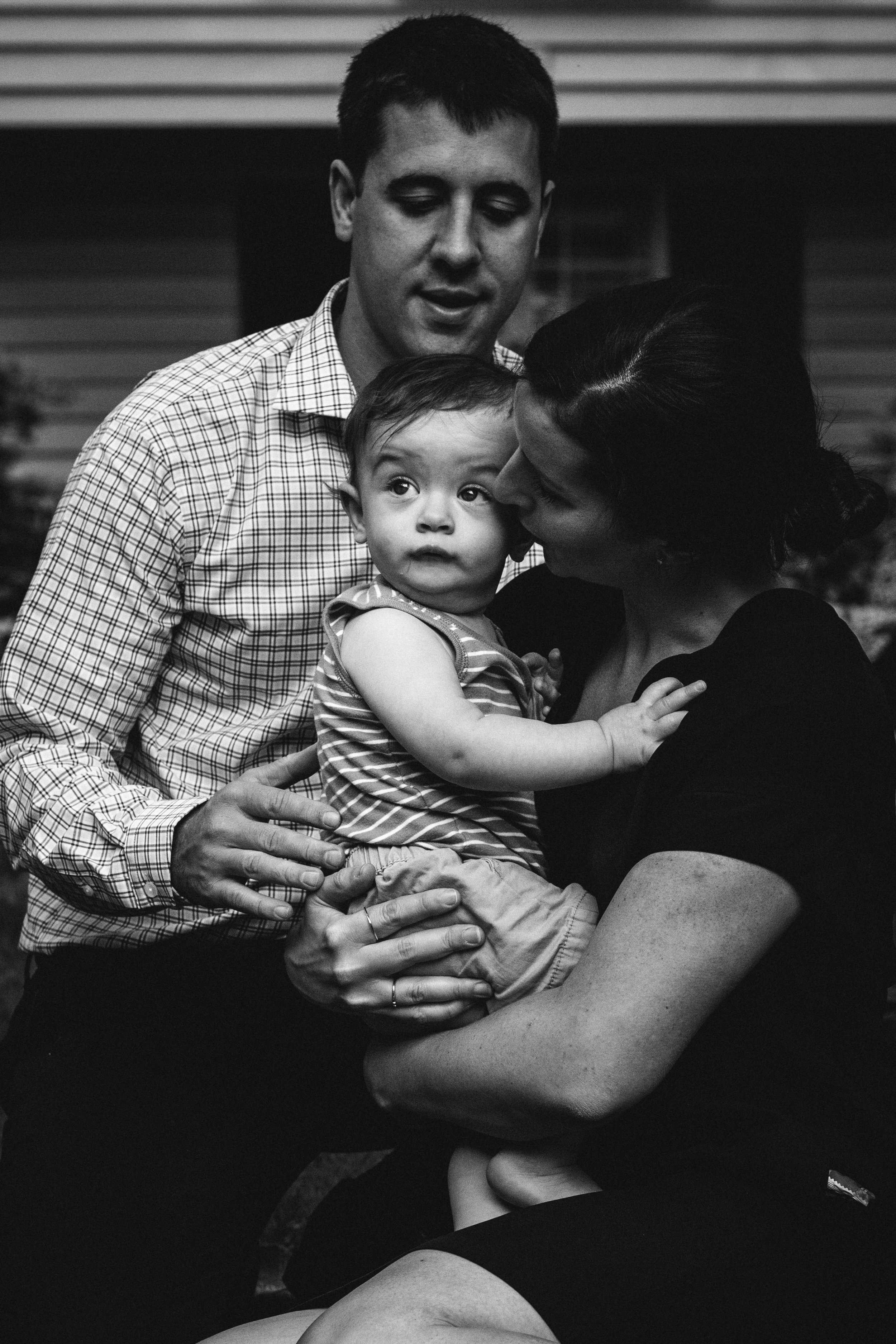 black and white photograph of parents cuddling baby son