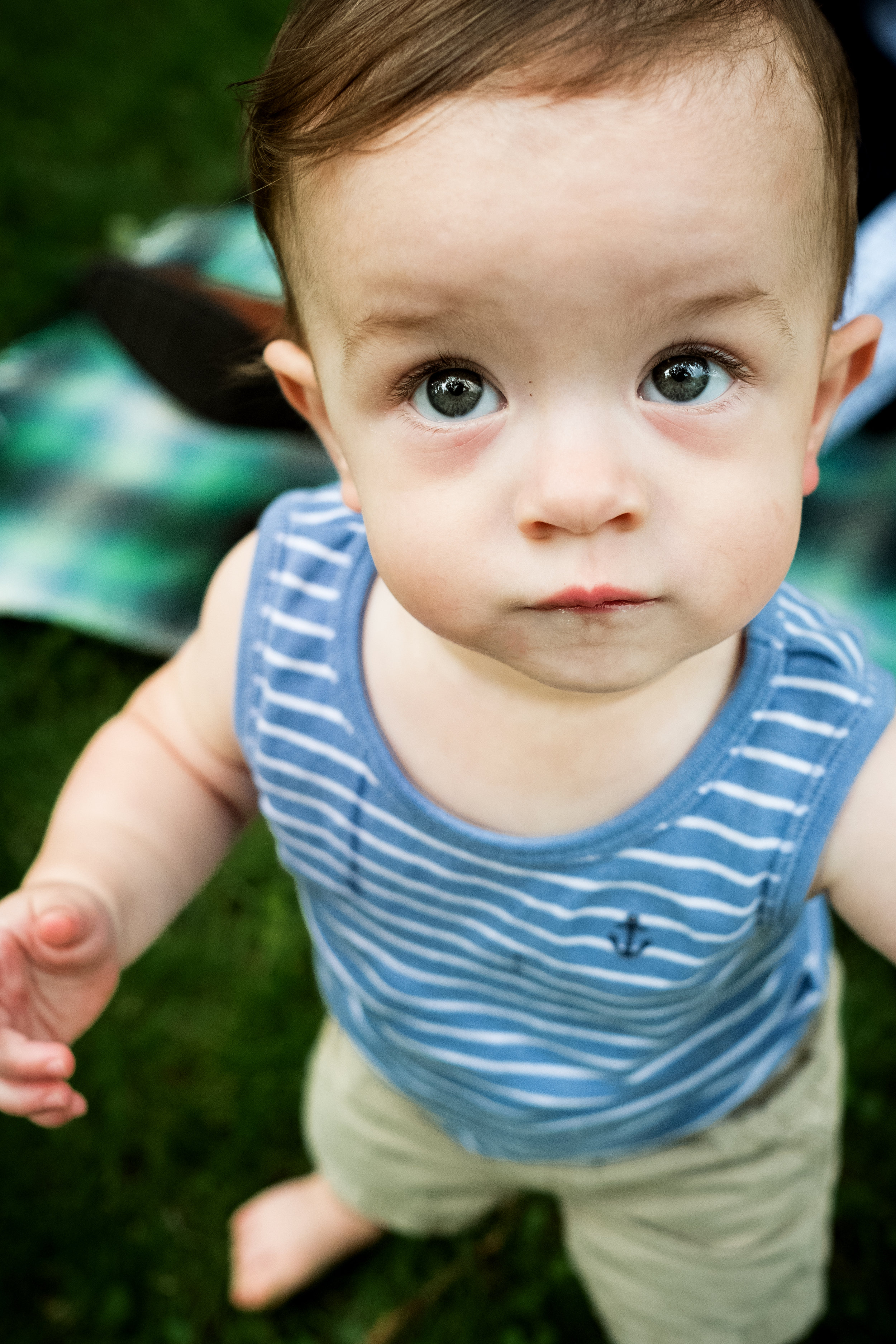 blue eyed boy in blue shirt standing outside