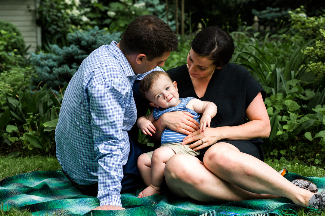 portrait of family holding young son in lap for photograph