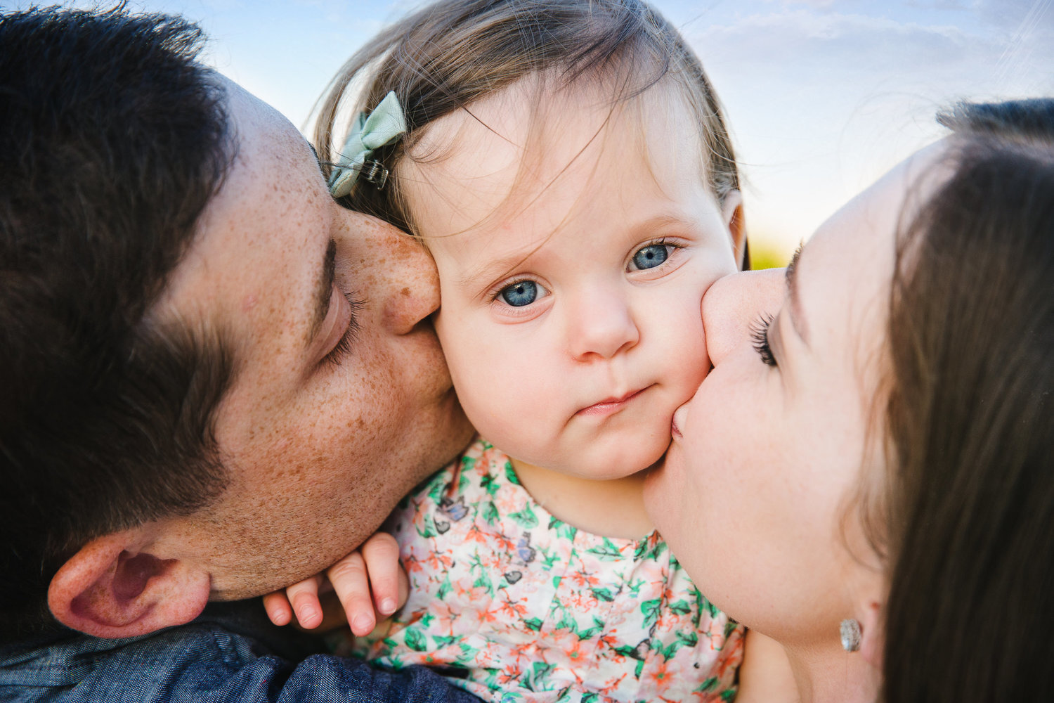 parents kiss small daughter