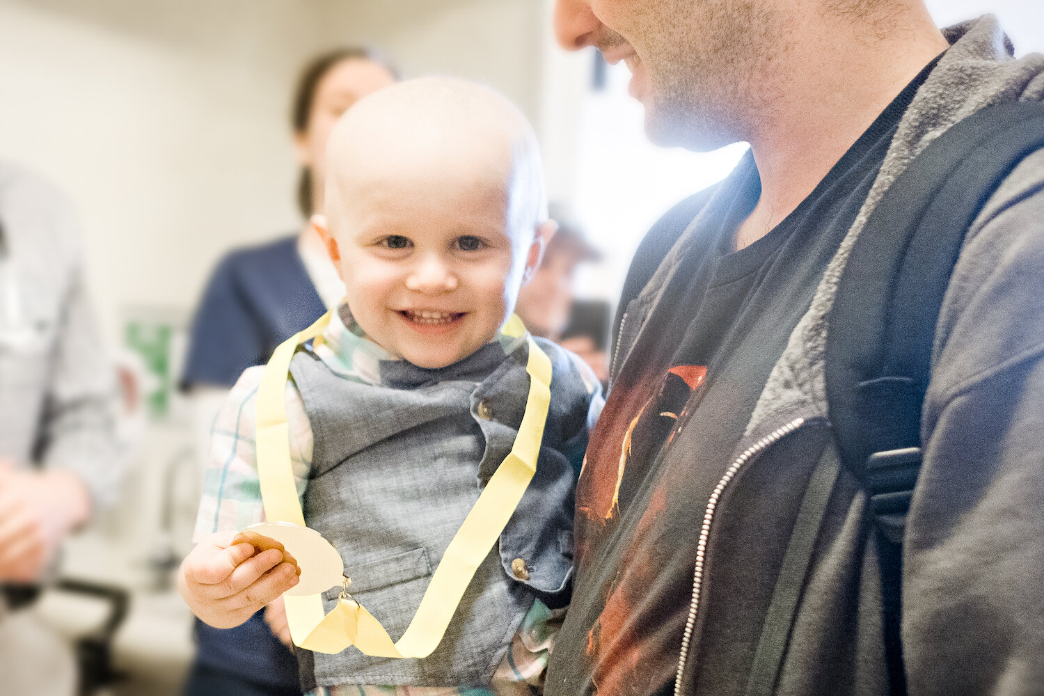 father-holds-young-son-as-boy-is-honored-for-completing-cancer-treament.jpg