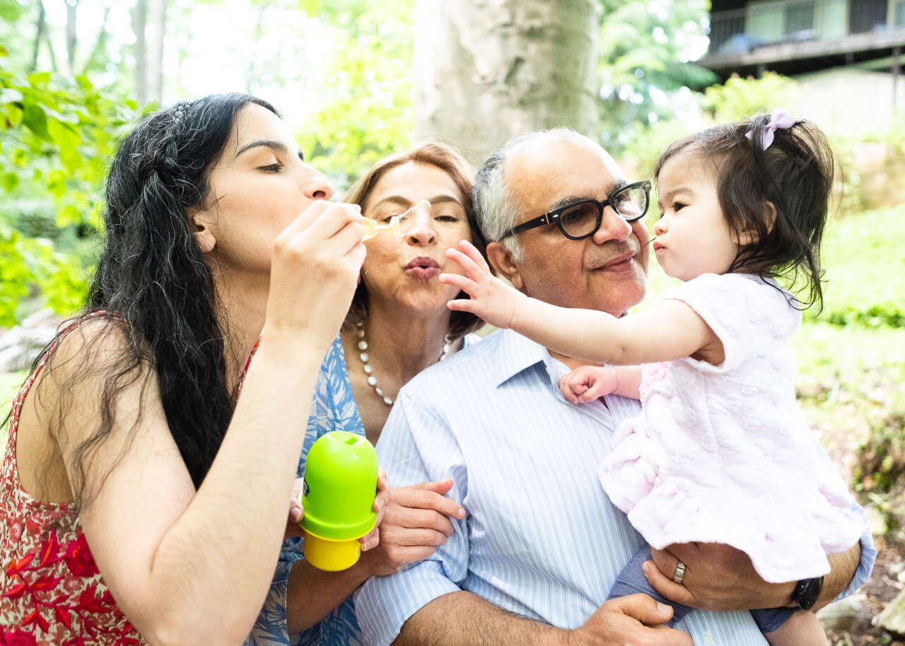 mom-blows-bubbles-at-daughter-with-grandparents.jpg