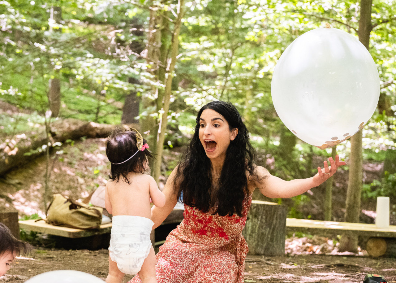 mom-playing-with-balloon-and-daughter-wearing-diaper-outside.jpg