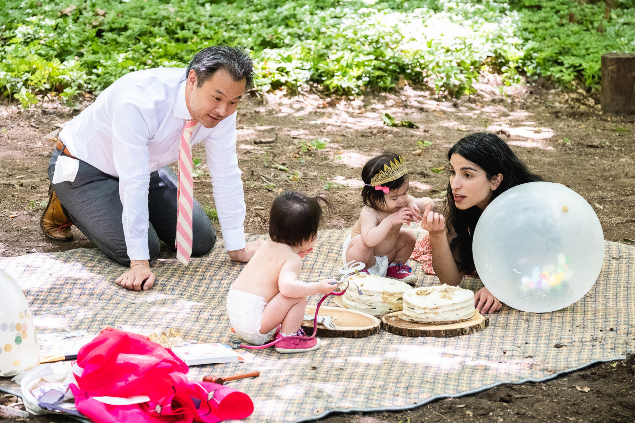 parents-and-girls-at-first-birthday-party-eating-cake-in-back-yard.jpg