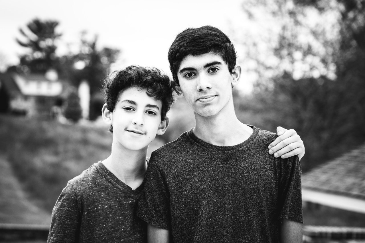 black-and-white-photograph-of-teen-brothers-shoulder-to-shoulder-in-family-photo.jpg