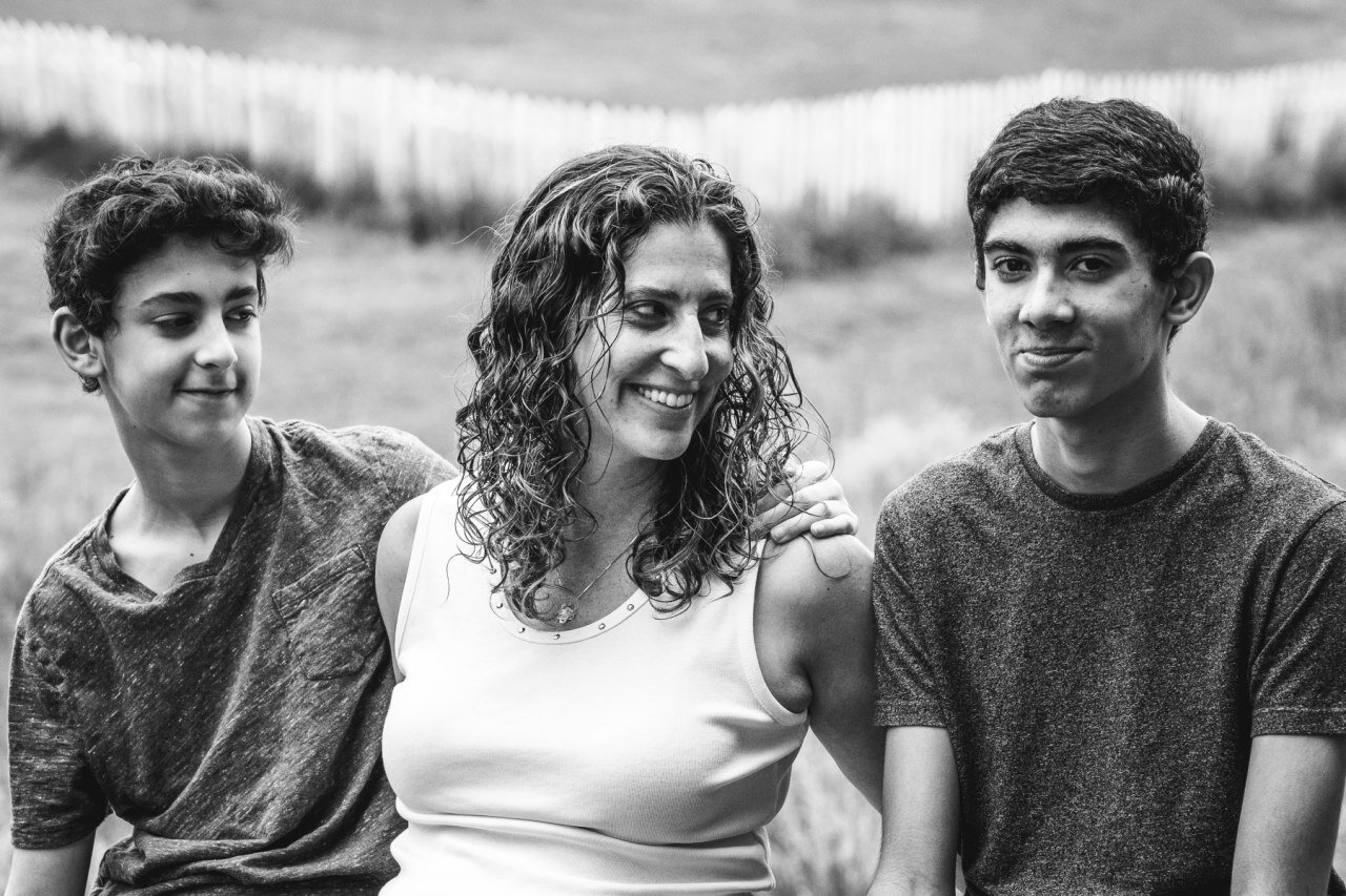 mom-smiling-with-two-teen-sons-in-black-and-white-portrait.jpg