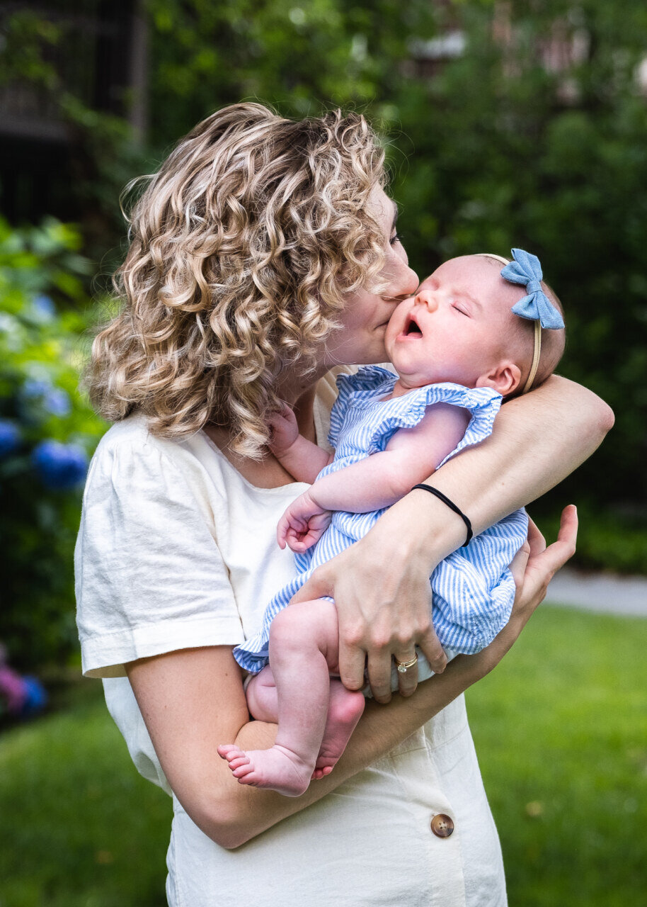 Newborn_girl_kissed_by_mom_in_home_garden.jpg