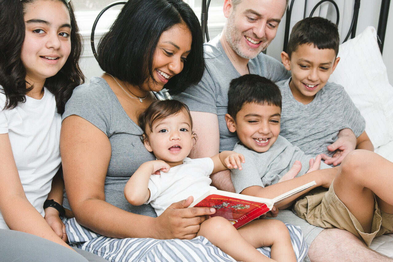 familY_reading_together_laughing_in_bed.jpg