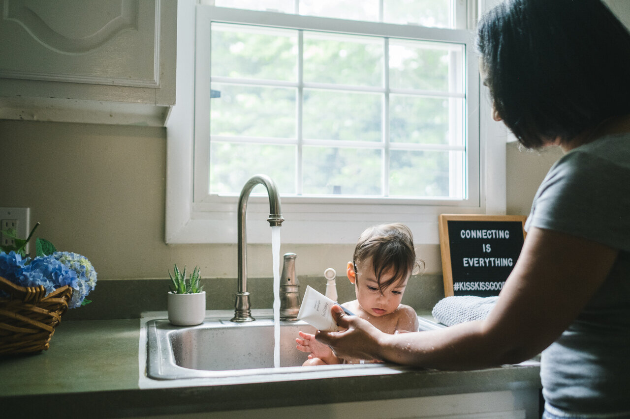 mother_washing_daughter_in_sink_bath_with_featured_product_in_branding_photos.jpg