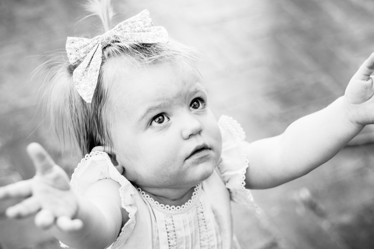 black and white photograph of little girl holding arms to be picked up by father