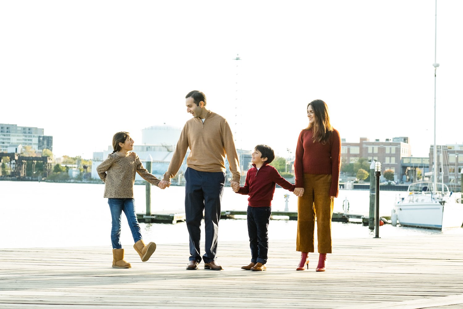 family of four holds hands by Baltimore Inner Harbo