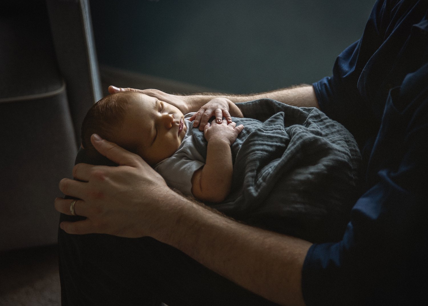 newborn sleeps in fathers lap