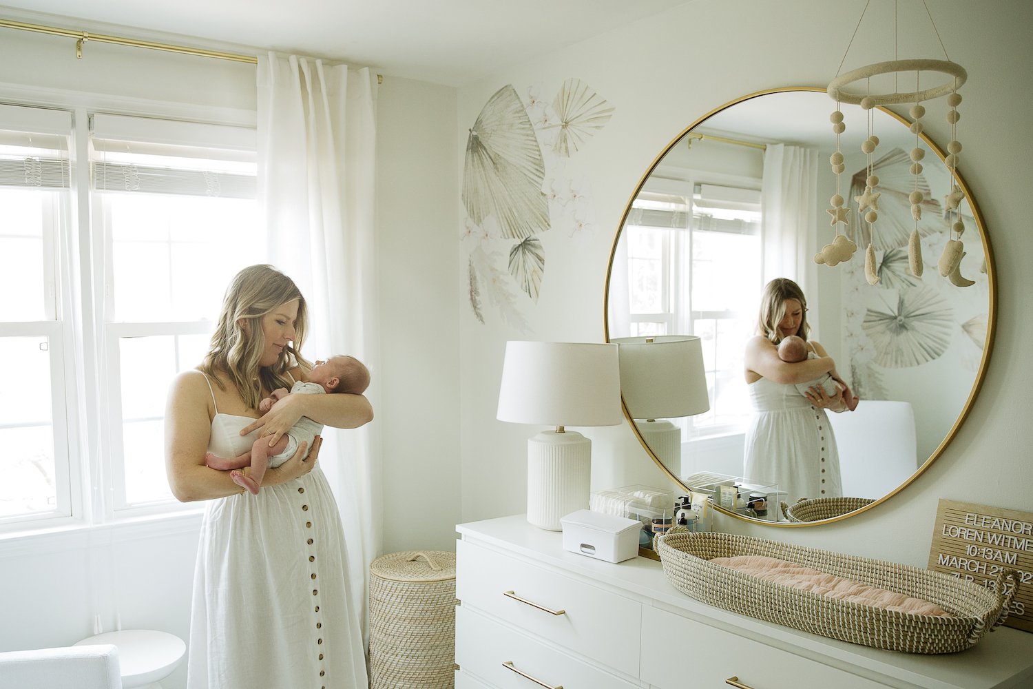 mother holds newborn by window