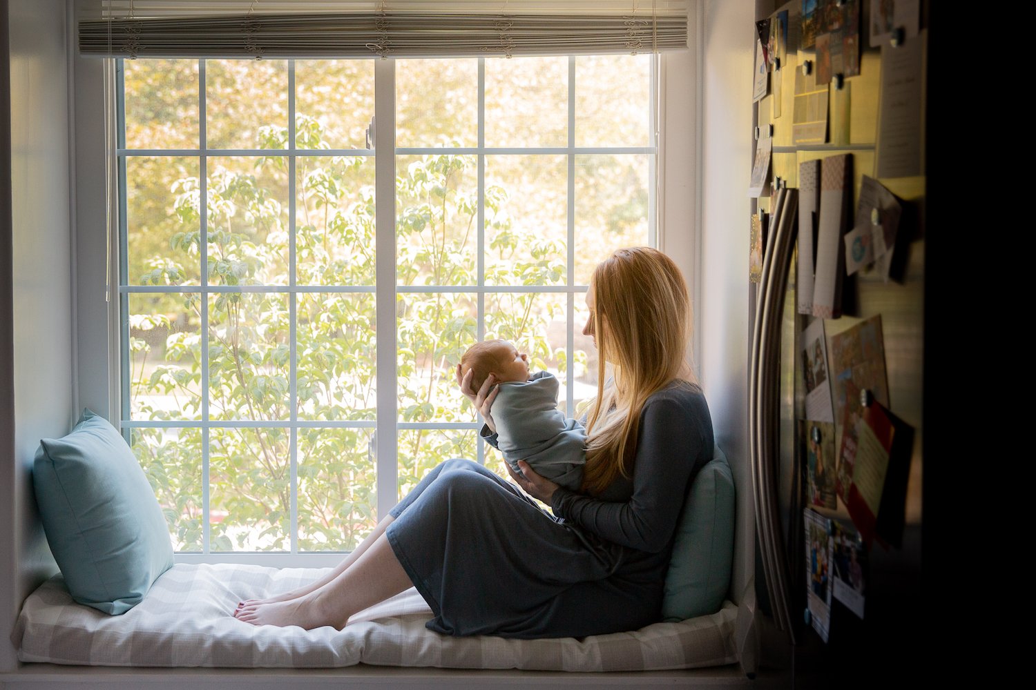 mother_holds_baby_by_window.jpg