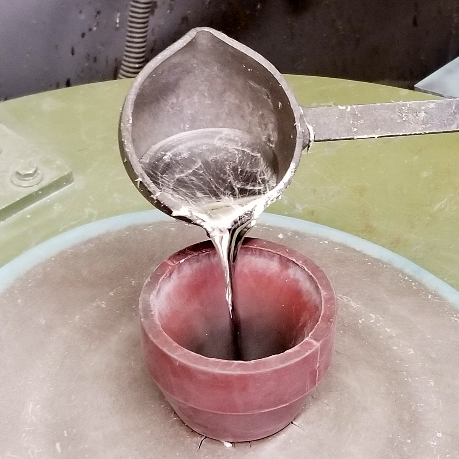 Pouring molten pewter into the mold