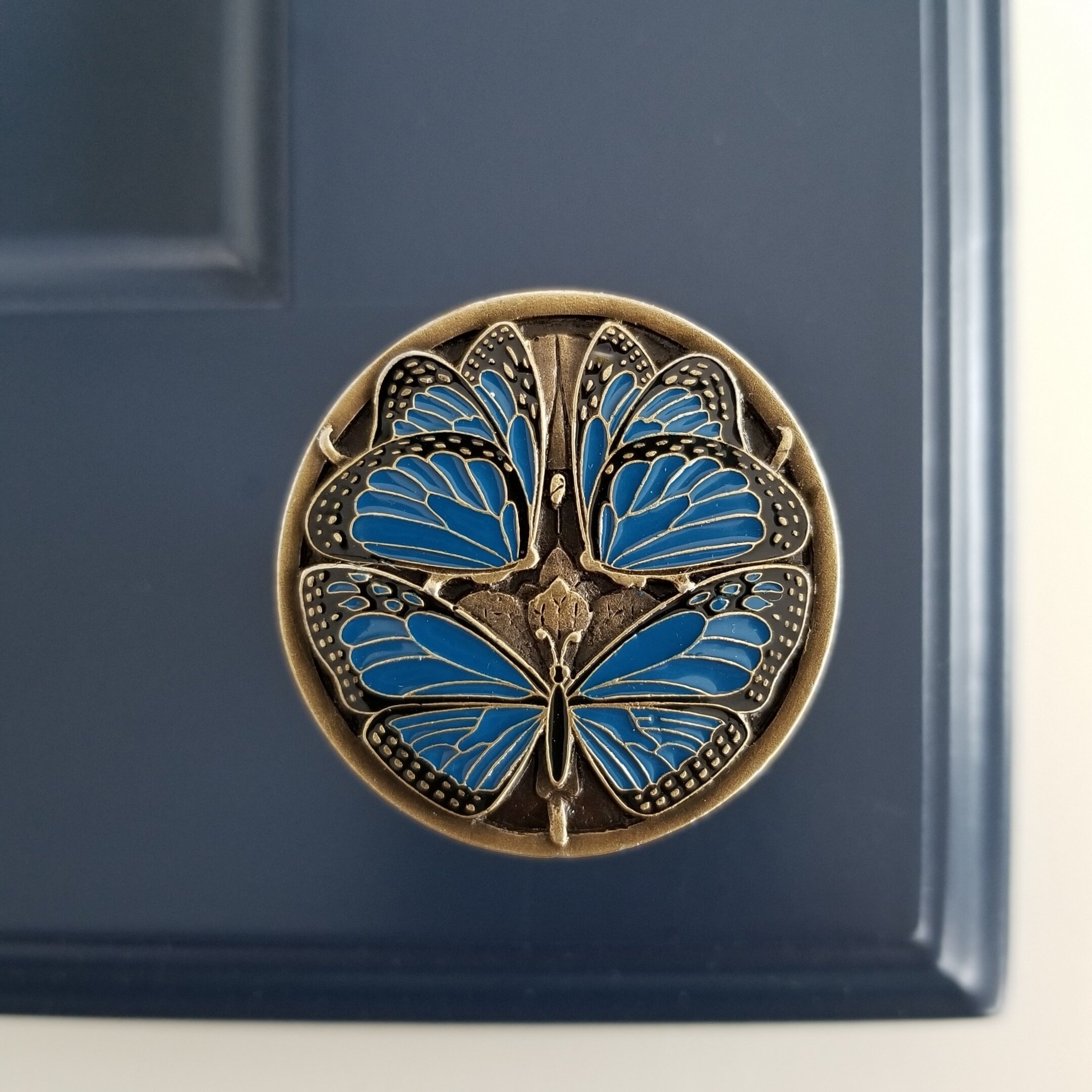 Blue Butterflies in Antique Brass on blue cabinet