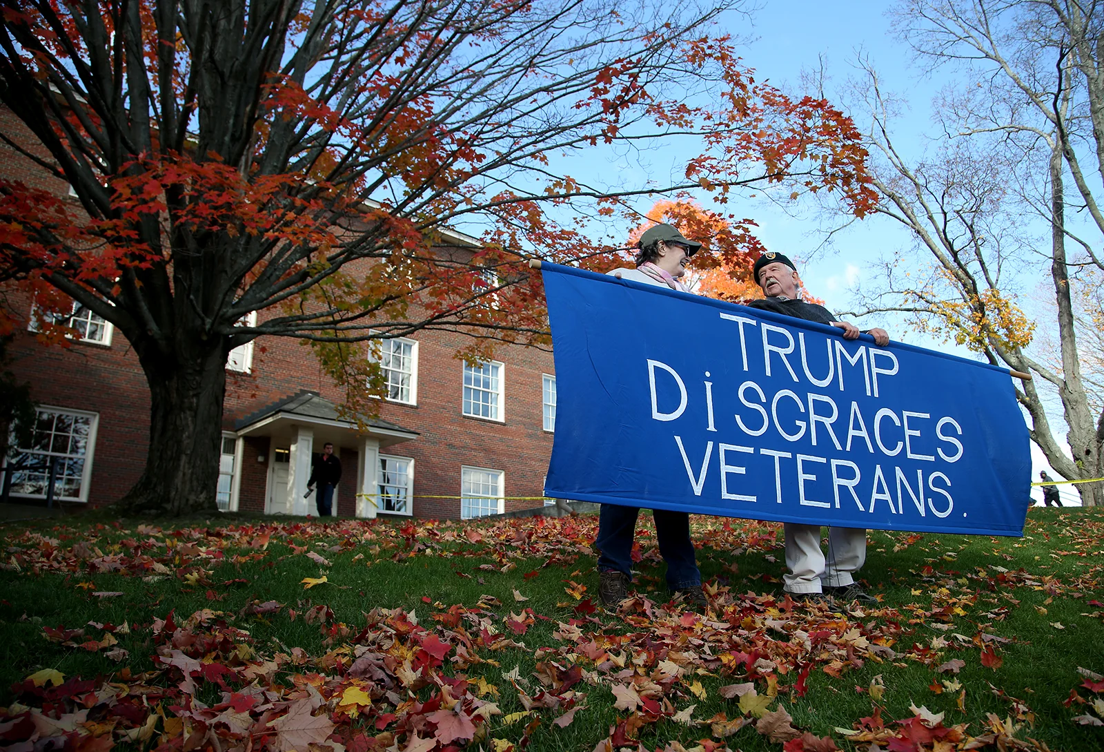 Veteran Linda Ewing, 68, the first woman professor at West Point, holds a sign alongside Vietnam veteran John Jones, 76, before the start of a rally for Hillary Clinton in Manchester, N.H. on Oct. 24.