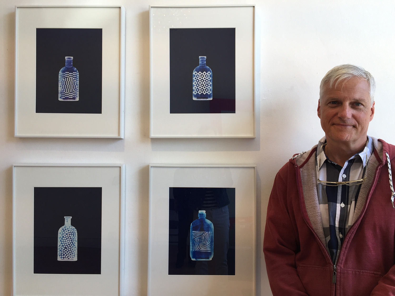 Greg Wilson standing beside a collection of his C Prints.