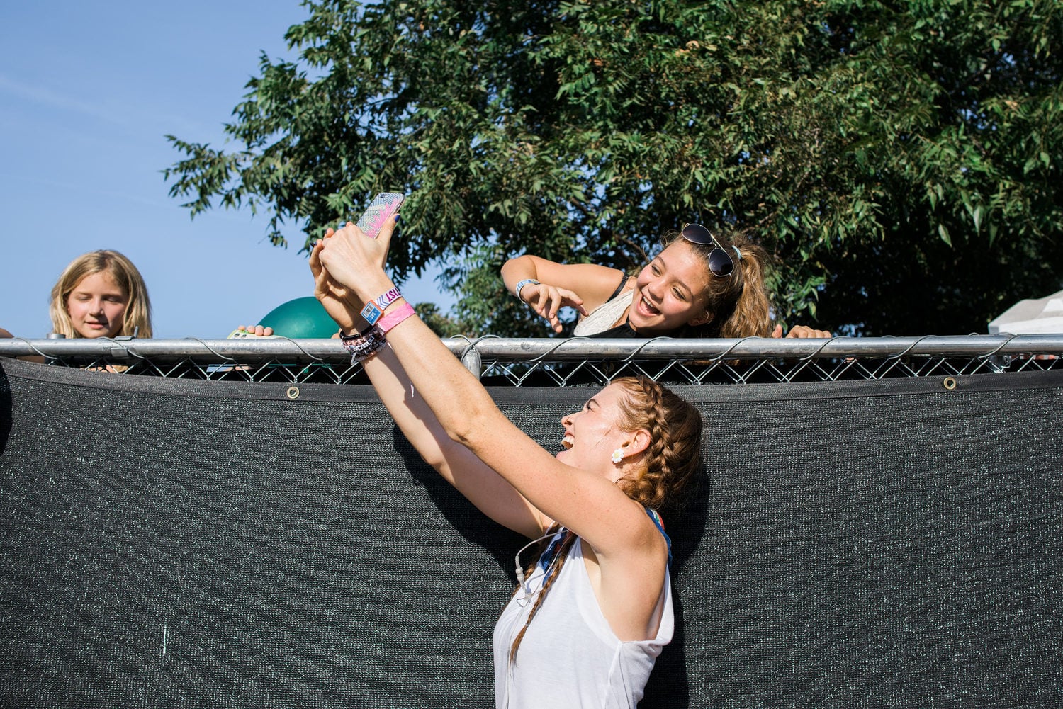 Misterwives taking selfies over a fence