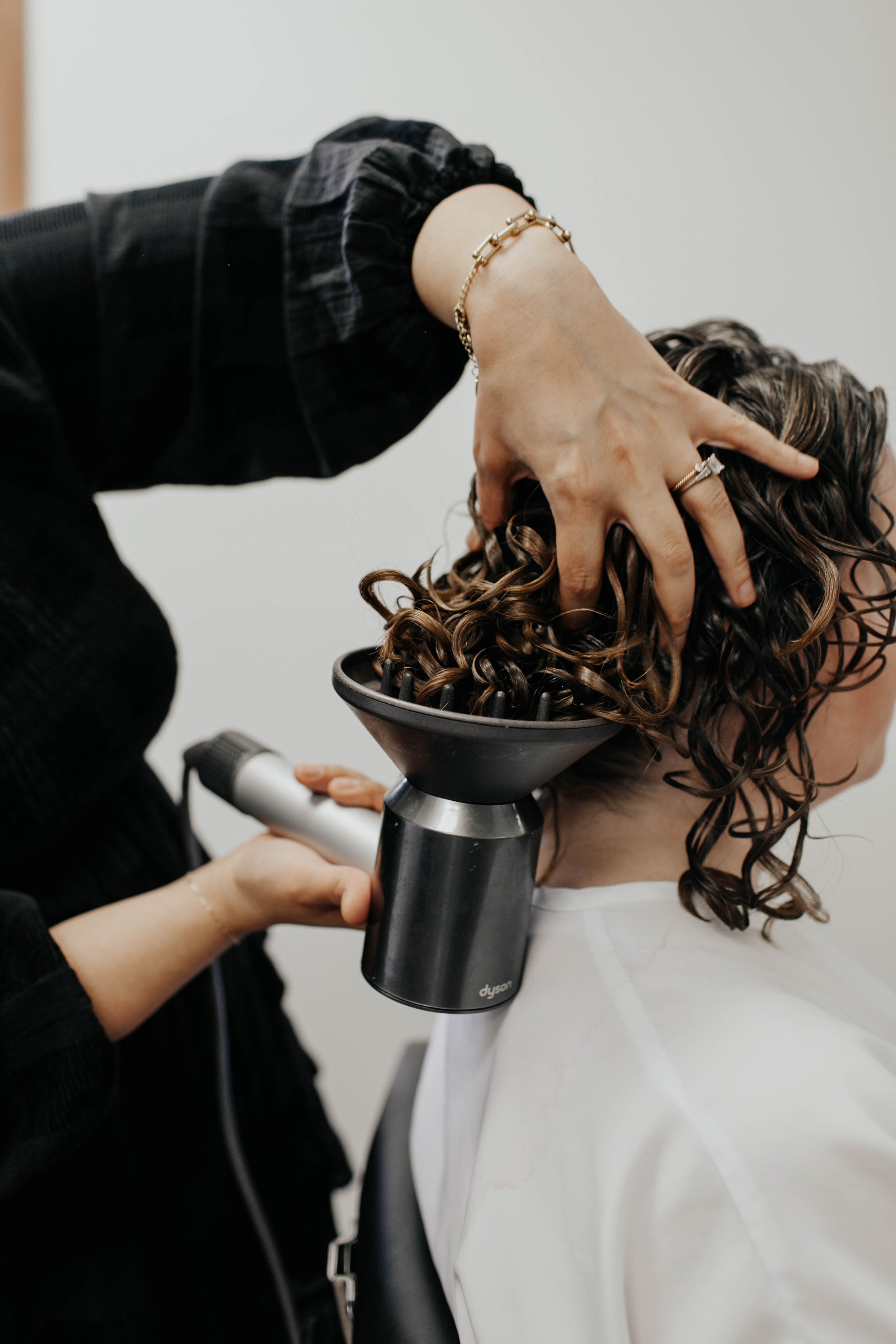 Stylist diffusing a client’s curly hair to enhance curl definition during a professional curl service at Siren Curl Studio.
