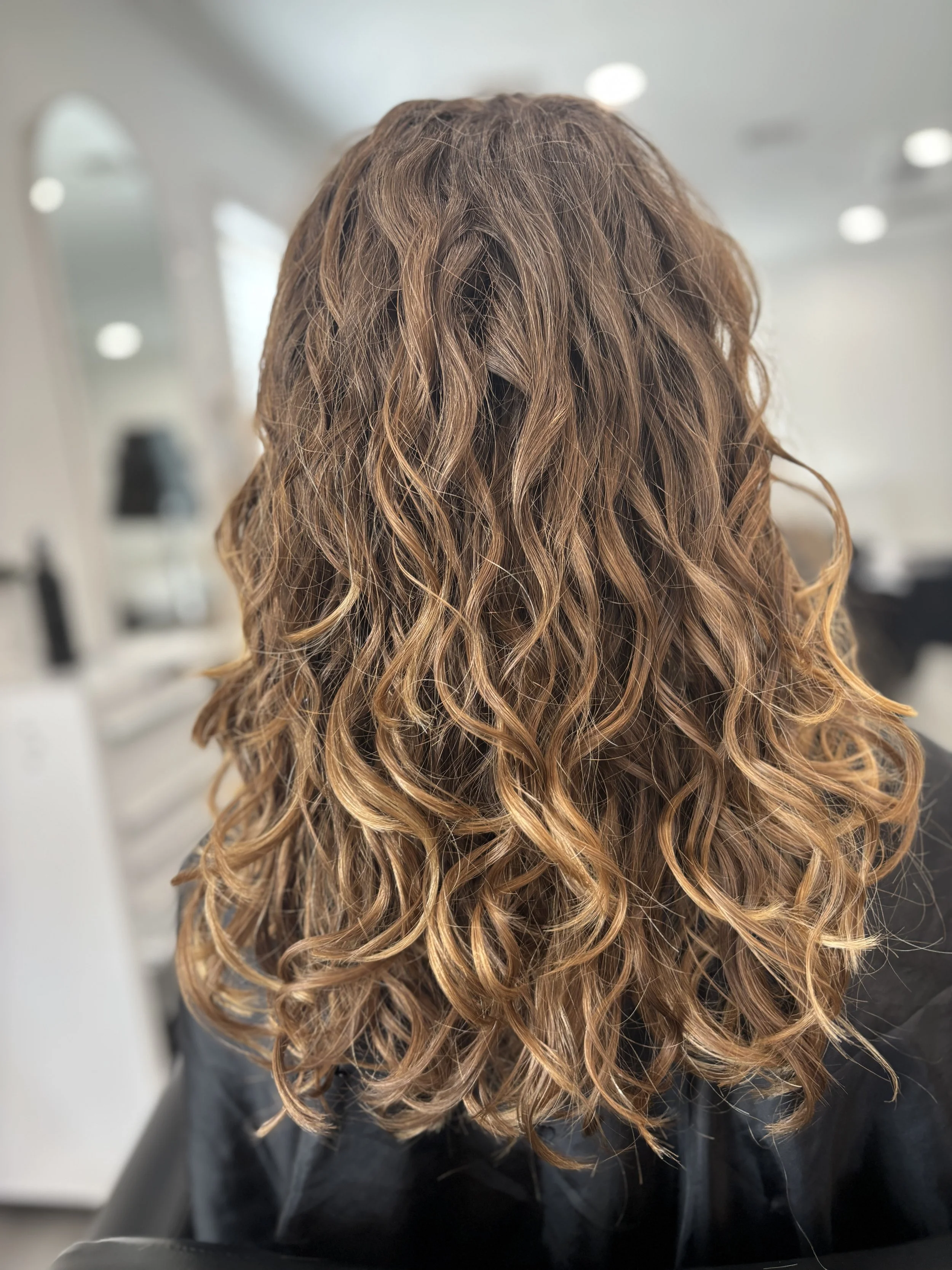Client with curly hair showing defined curls after a Siren Curl Session.