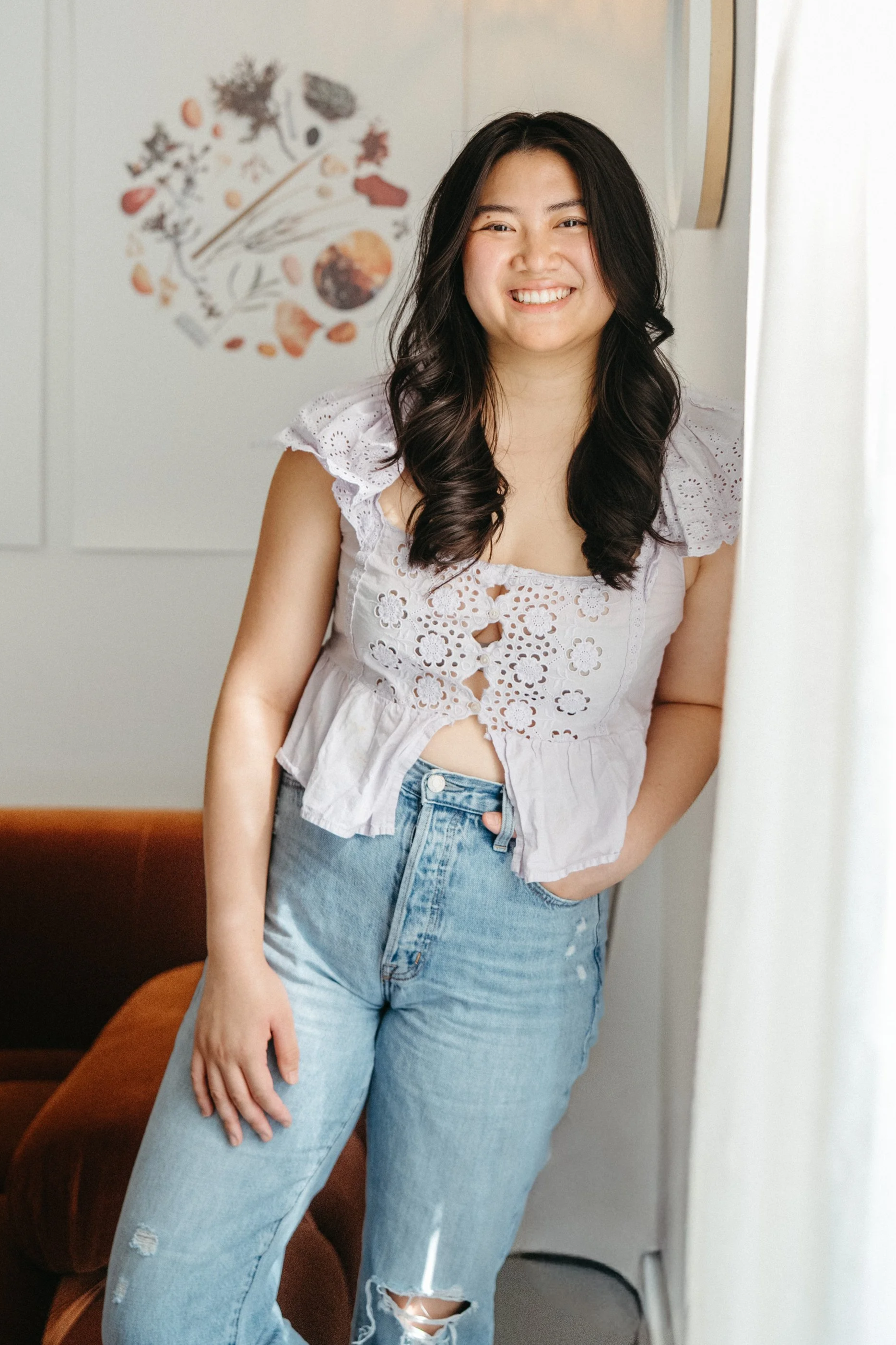 Helen, a Siren hairstylist, smiling while leaning against the wall inside Siren Curl Studio.