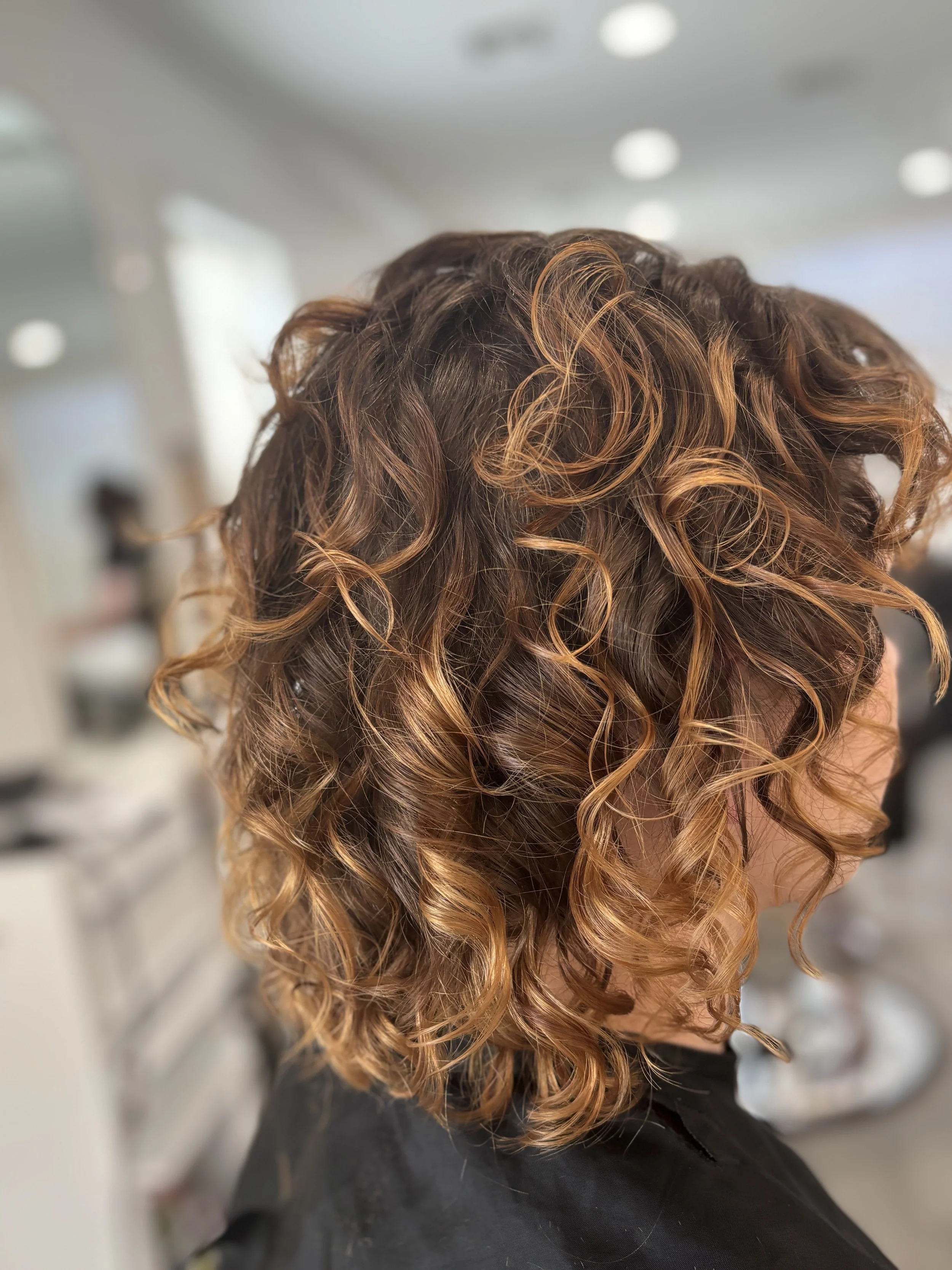 After result of a Siren Color Session by stylist Jasmine, featuring beautifully highlighted and styled curls.