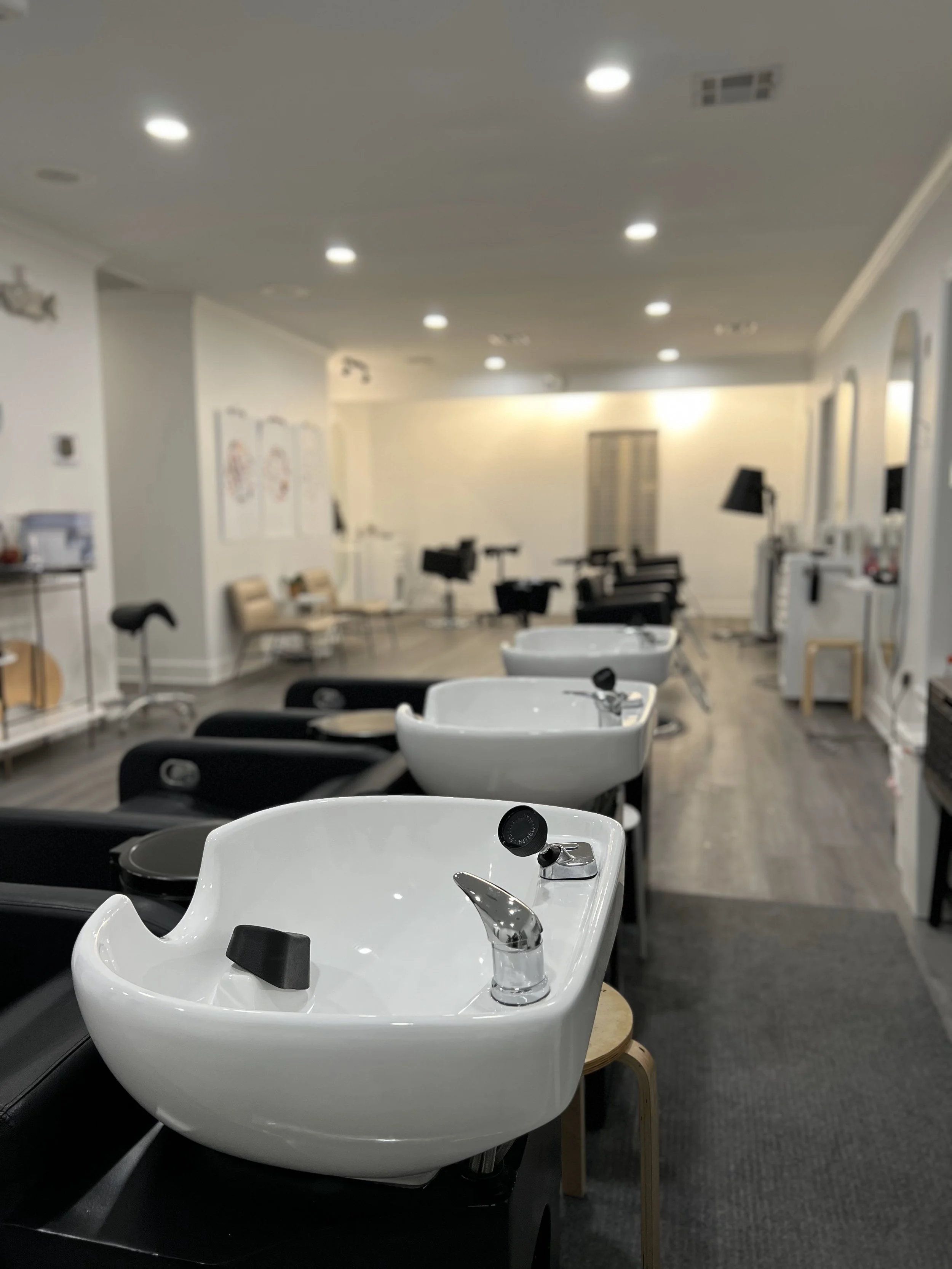 Interior of Siren Curl Studio showcasing shampoo bowls and a calming, aesthetic salon atmosphere designed for a relaxing curl care experience.
