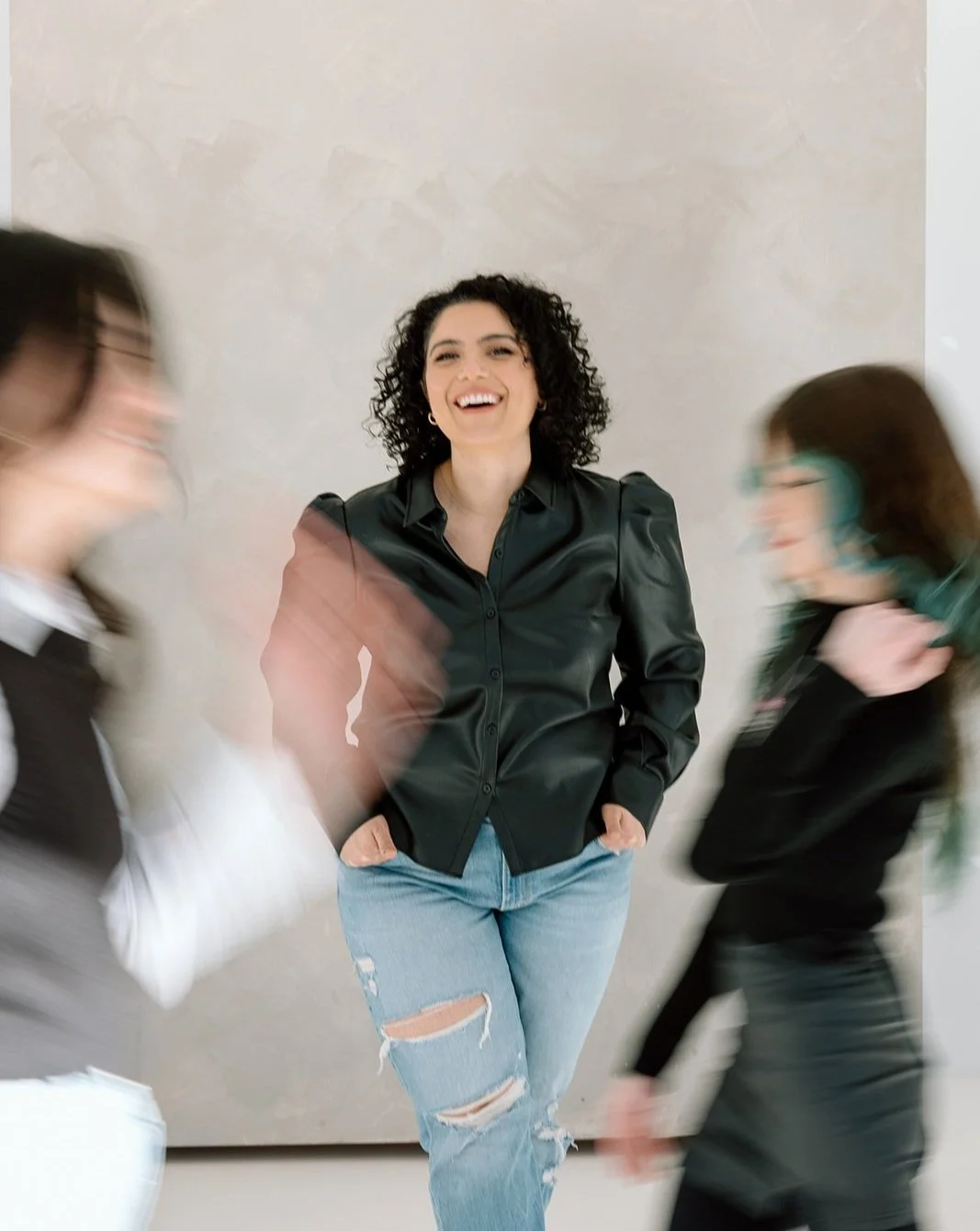 Team photo at Siren Curl Studio with owner Shirin smiling in the center, highlighted in focus while two stylists appear softly blurred in the background.