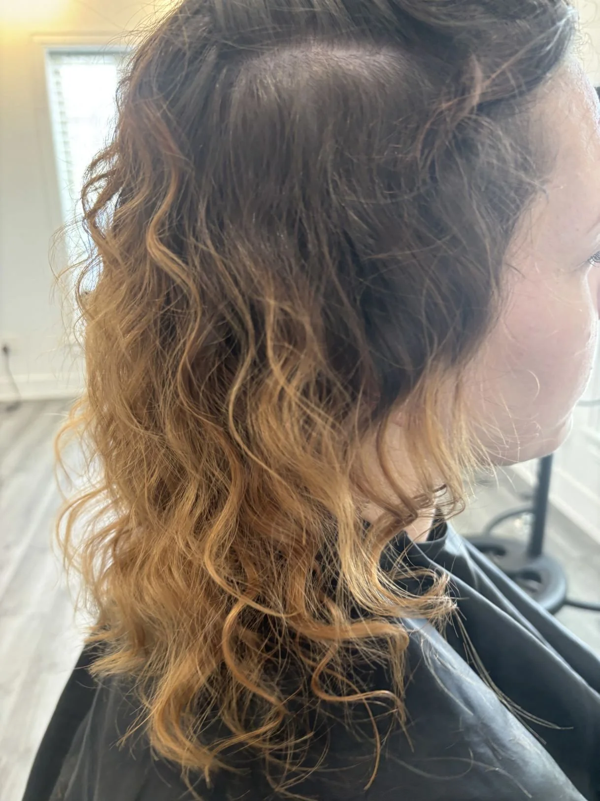 Before photo of a Siren client with grown-out color before a sun-kissed highlight service.