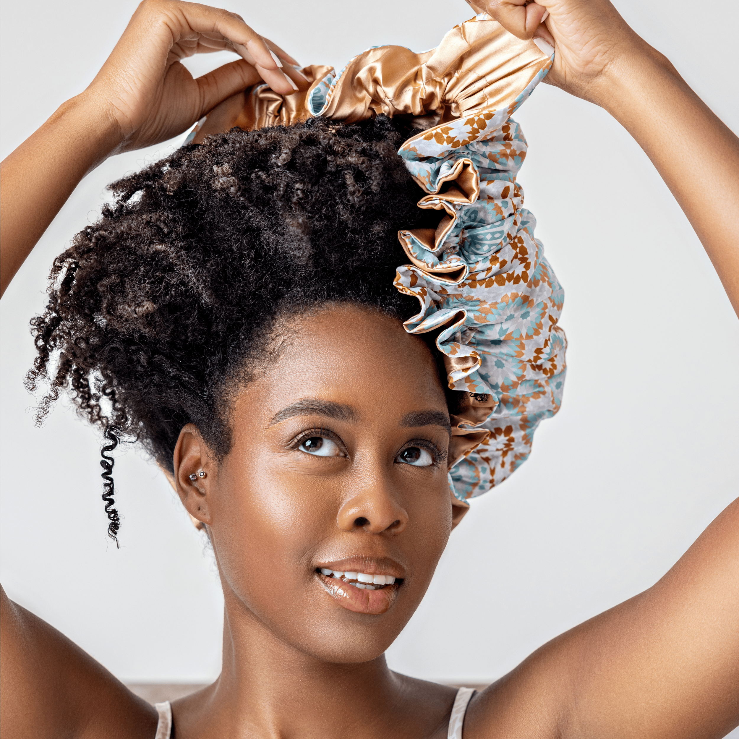 A woman with tight coils wearing a silk bonnet