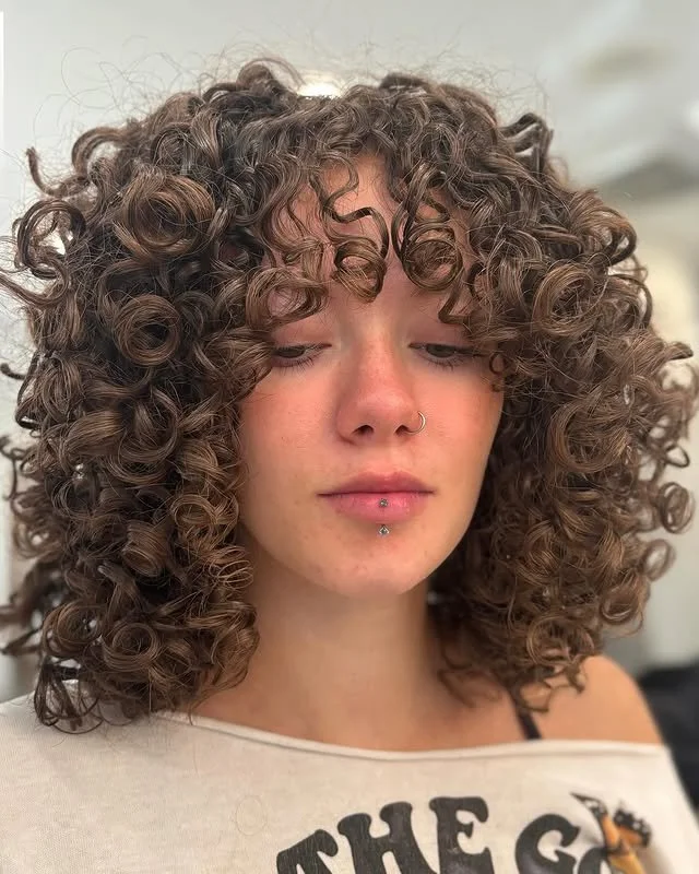 After result of a Siren Curl Session by stylist Jasmine, featuring beautifully styled curls with soft, face-framing bangs.