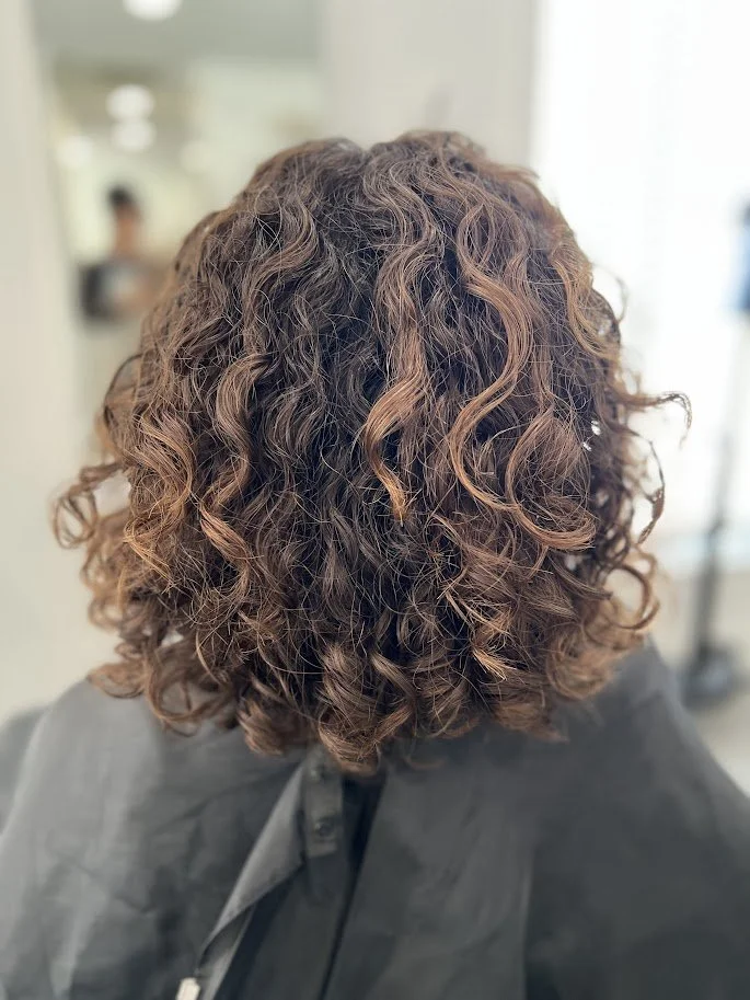 Before photo of a Siren Curl Studio client with undefined curls prior to a curl-enhancing haircut.