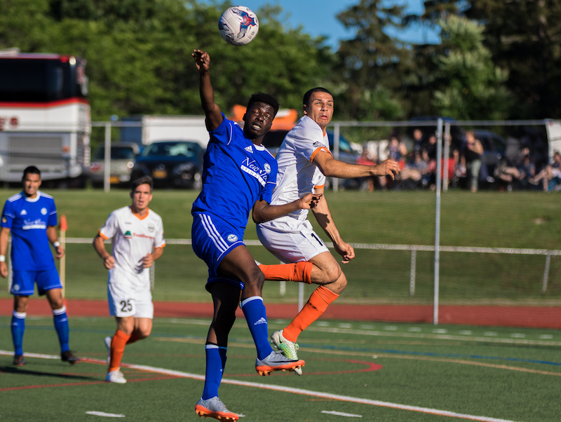 Stockade's Brandon Curtis goes up for a header against TSF FC. (Photo by Leanne Keator, Ride the Tide Photography )