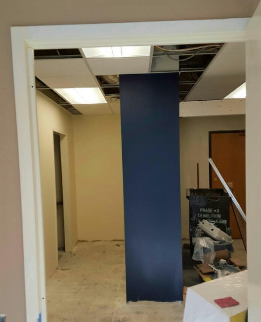 The Gentlemen's Gray colored wall by Benjamin Moore creates a cove for the paralegal's work area, at the same time introducing a bold color pop for clients entering into the reception area.