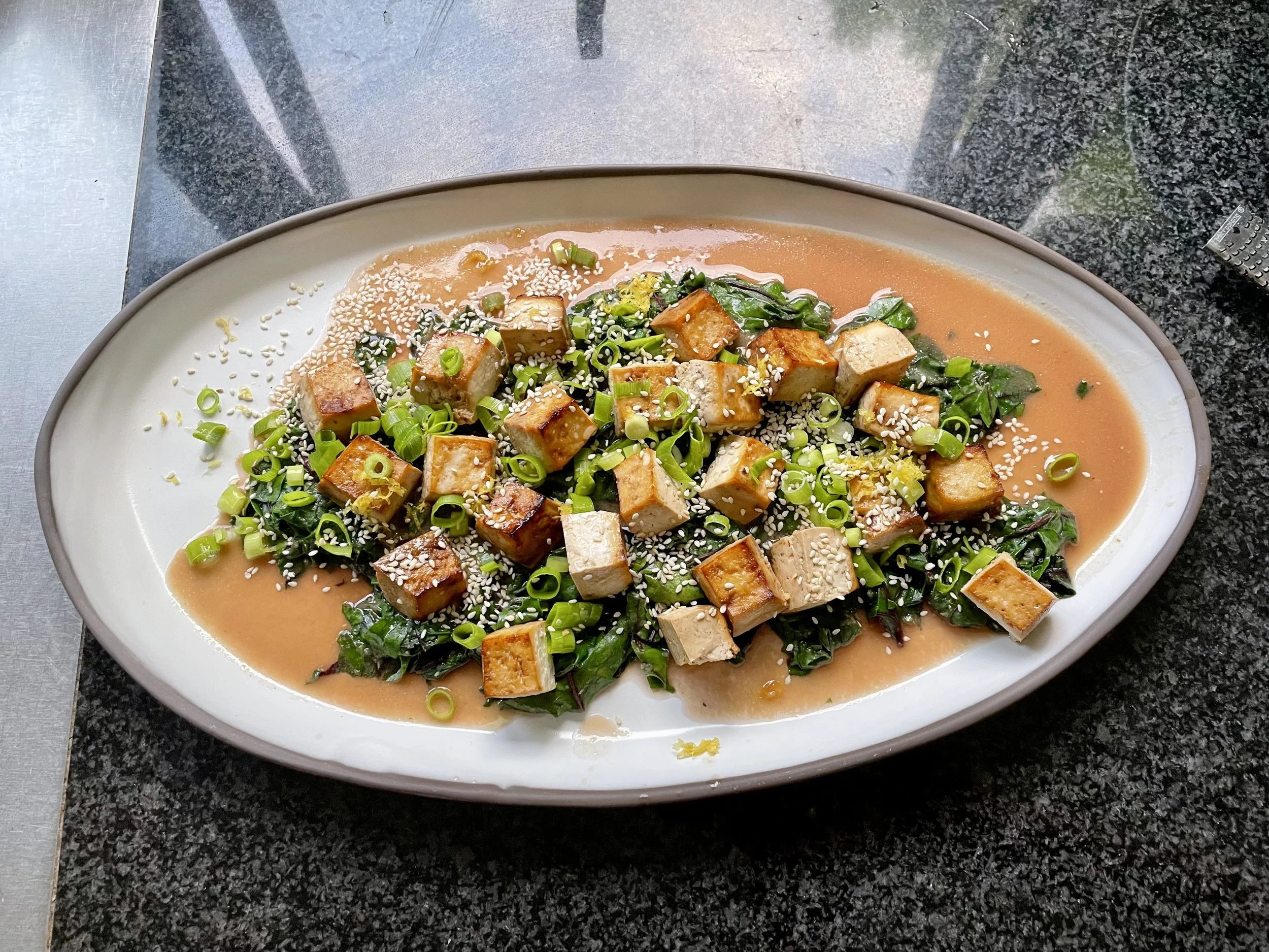 Delicious tofu on a bed of miso and greens