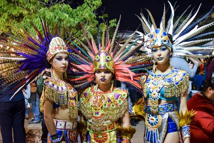 Performers wearing elaborate traditional costumes and feathered headdresses at a City of Edinburg cultural festival.