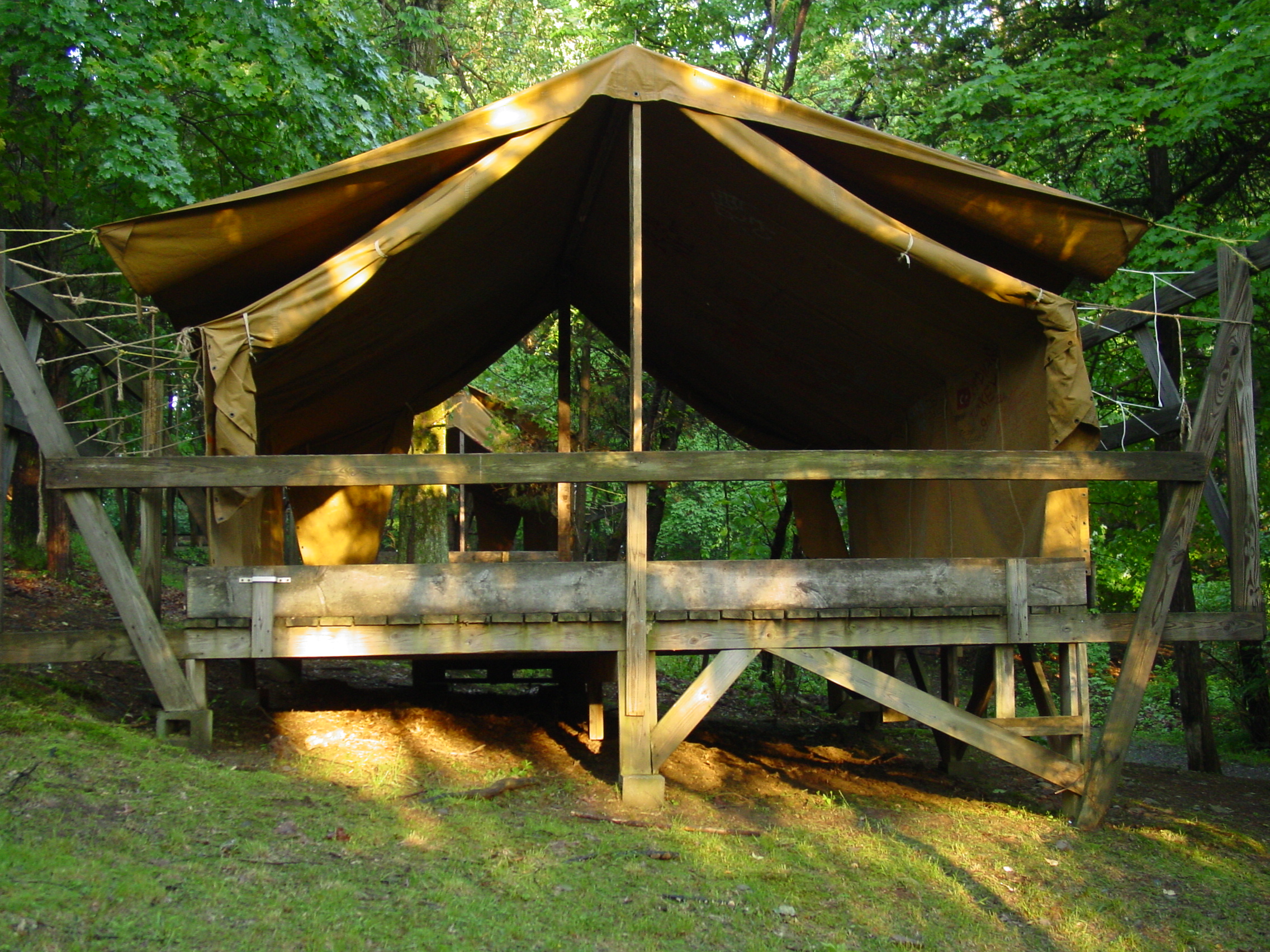 Campers sleep on cots in wooden-platform canvas tents like these.