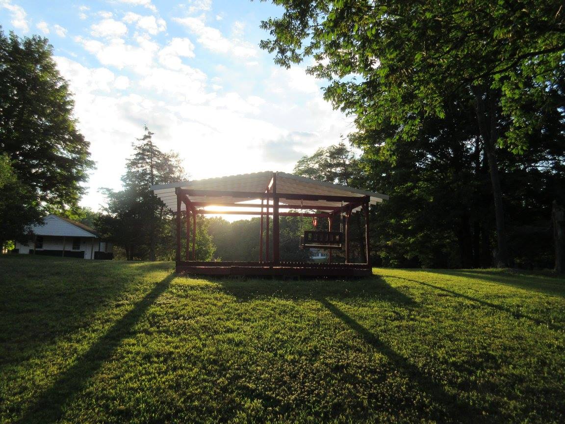  A camper built gazebo sits atop Cabin Hill, surrounded by Art, Drama, Hiking, and Projects Cabins, 