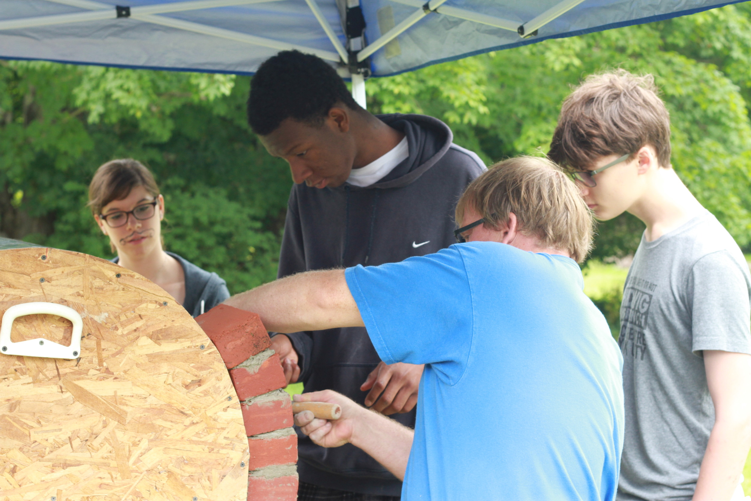  Campers building a brick wood-fire oven 