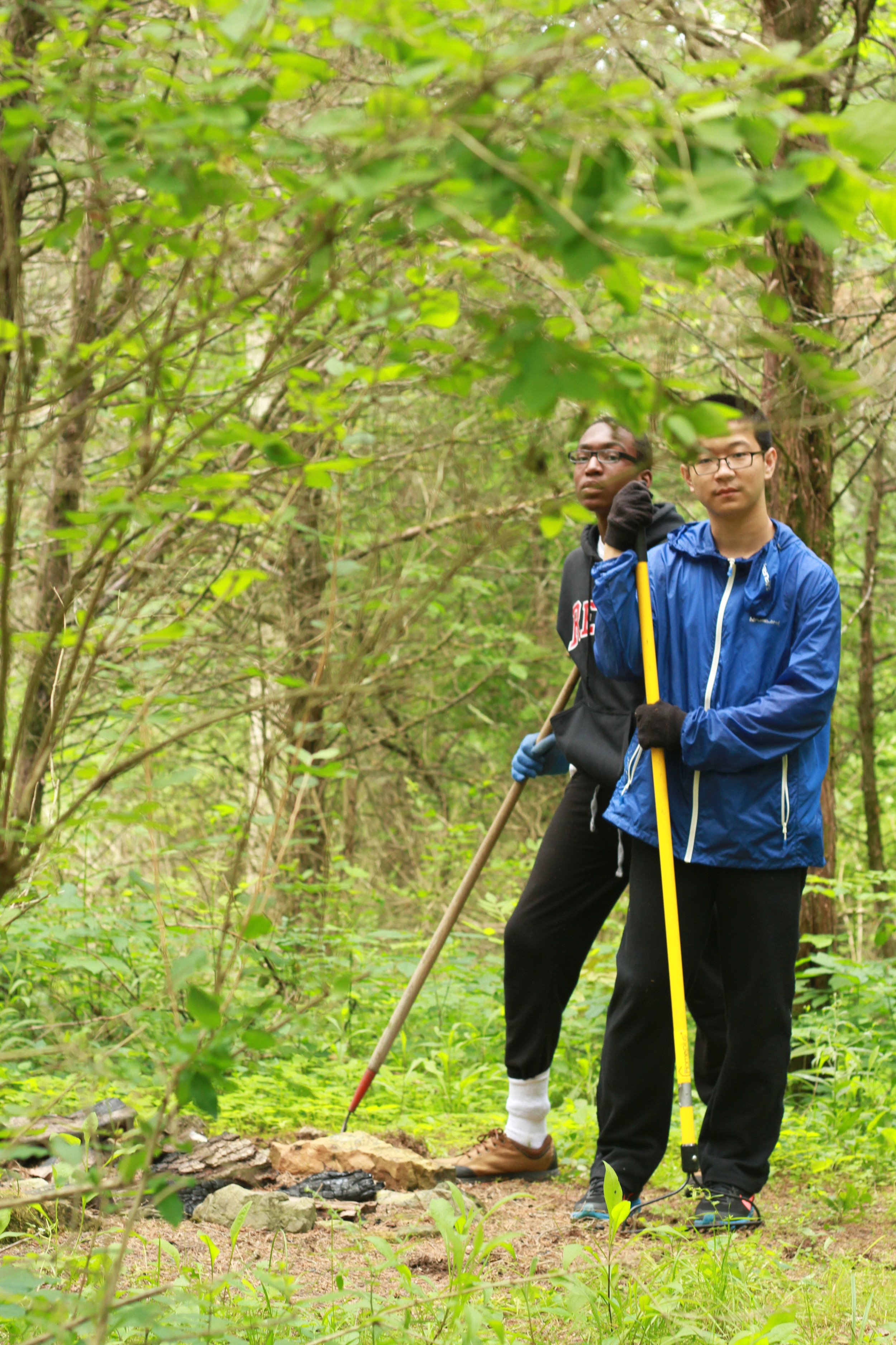  The Clinton campus features many trails beyond the main campus. Here, we see campers working on clearing a fire pit in the woods. 